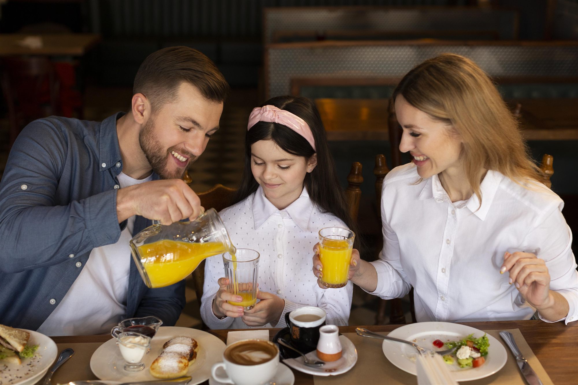 Família tomando café da manhã junta à mesa
